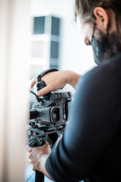 男子在黑色衬衫黑色台数码单反相机